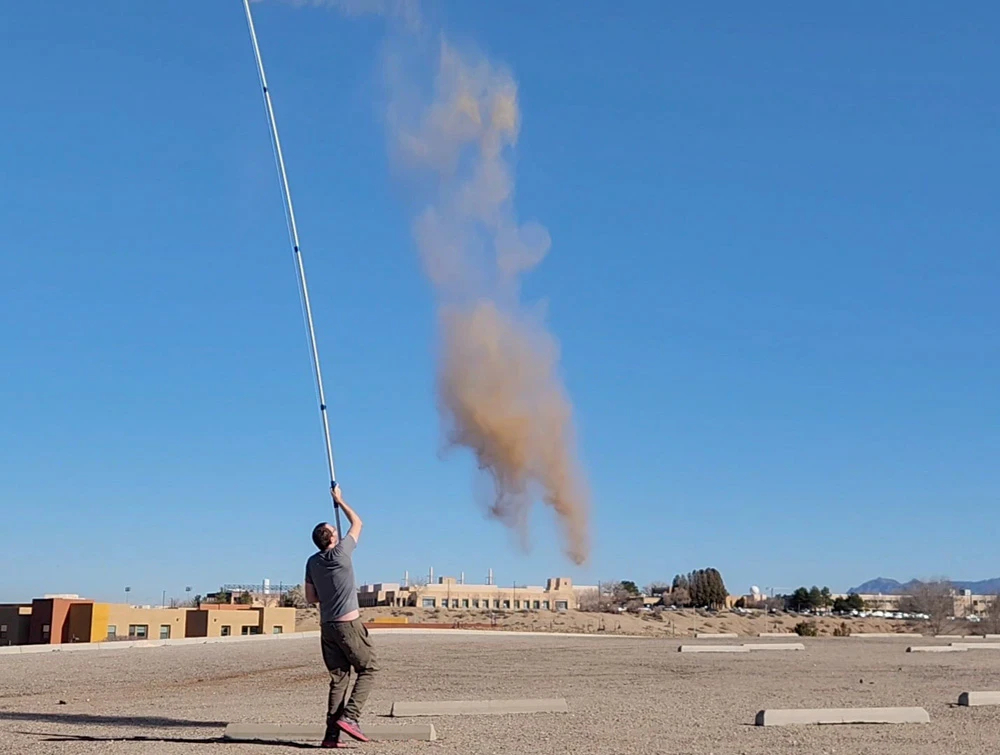 Testing dropping dust from a pouch at the top of a painting pole